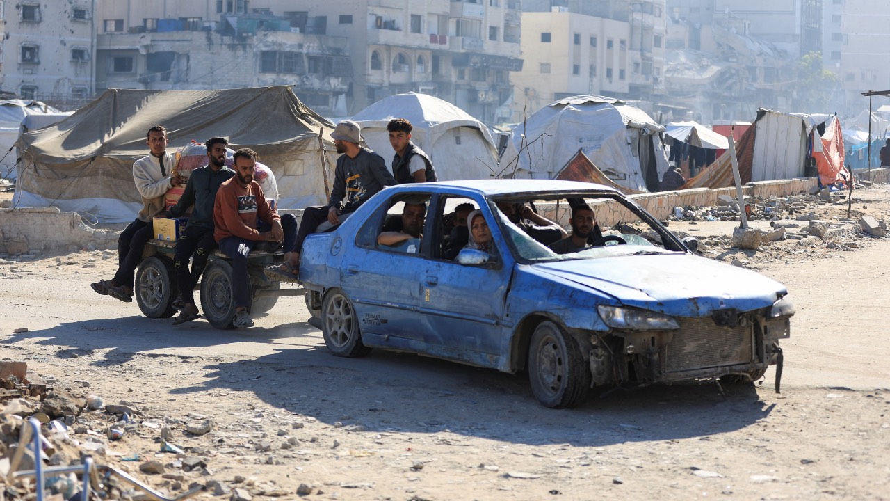 Palestinians in a car pull a cart with people on it, while driving near tents in Gaza City. /Dawoud Abu Alkas/Reuters