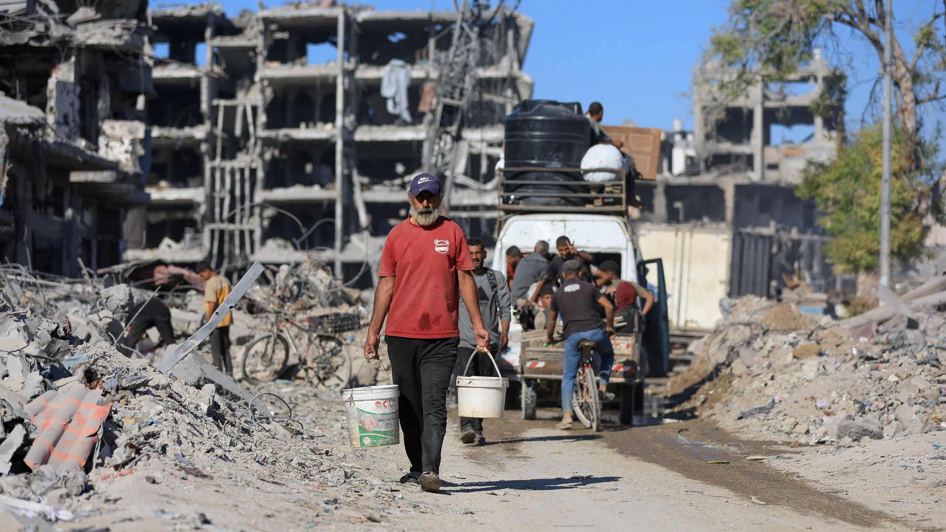 Palestinians amid destroyed buildings in Gaza City on Tuesday. /Dawoud Abu Alkas/Reuters