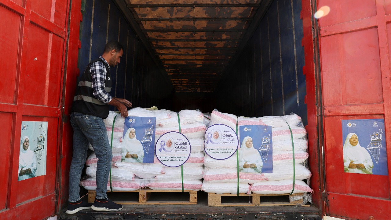 A man stands next to humanitarian aid from Egypt's National Alliance For Civil Development Work (NACDW) loaded on a truck, as it is on its way to the Rafah border crossing to enter Gaza. /Amr Abdallah Dalsh/Reuters