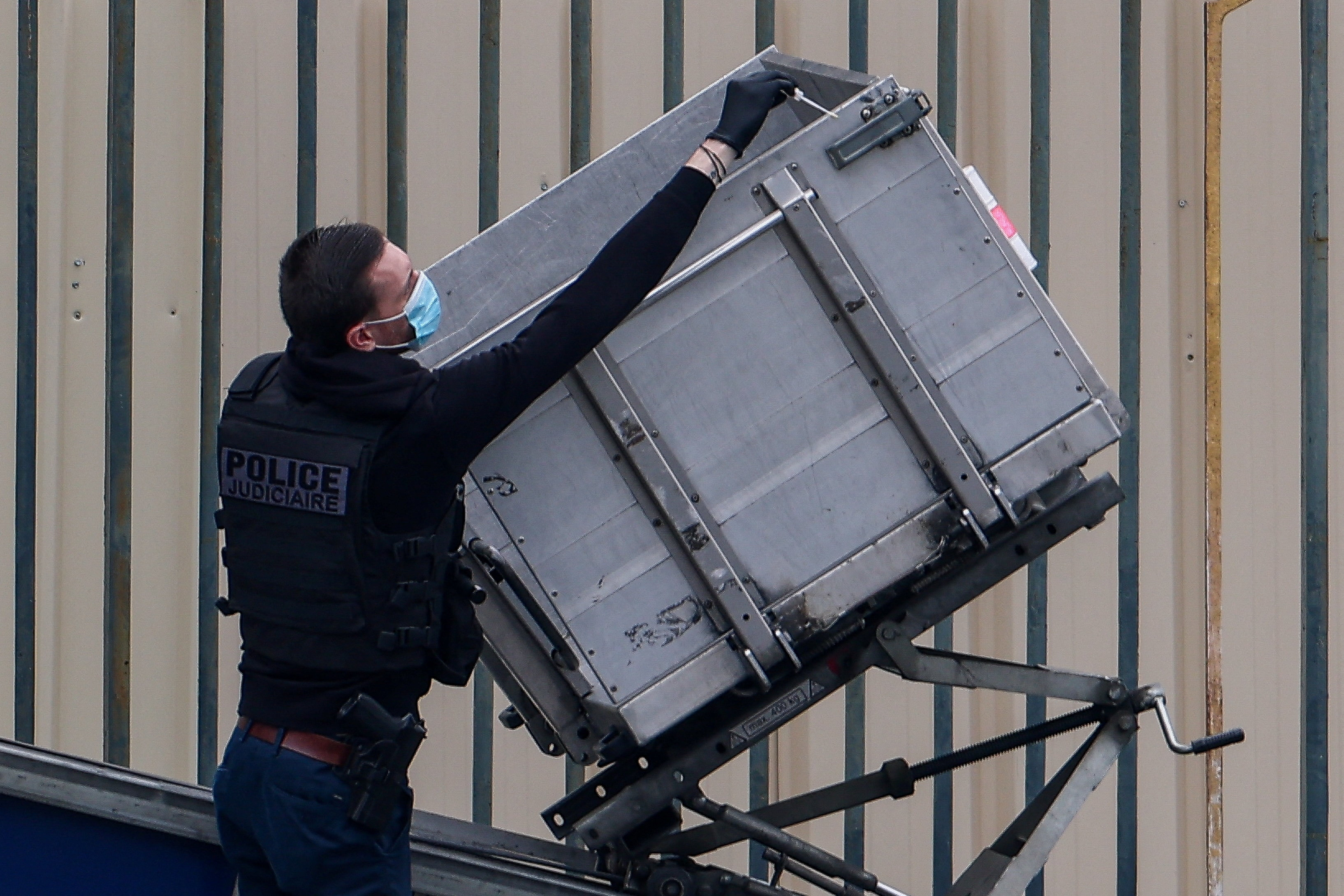 A police officer works at a crane believed to have been used in what the French Interior Ministry said was a robbery at the Louvre museum during which jewellery was stolen, in Paris, France, October 19, 2025. REUTERS/Gonzalo Fuentes