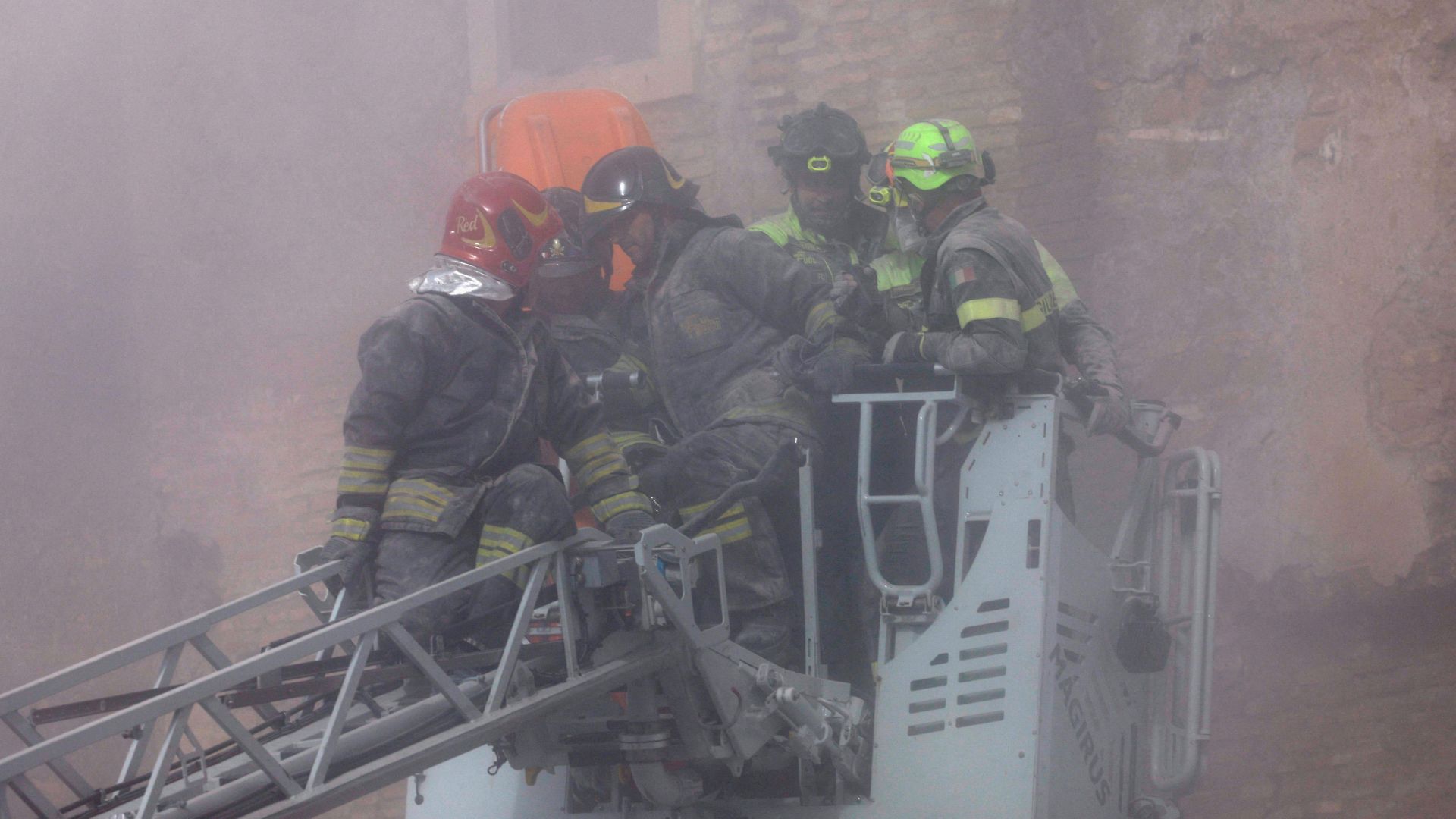 Dust rises after parts of the Torre dei Conti tower collapsed, as emergency service members work at the scene. /Remo Casilli/Reuters