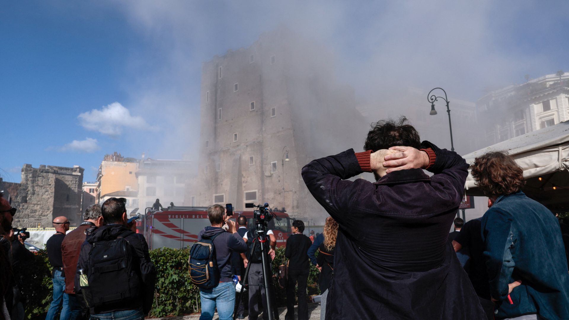 Onlookers watch as dust rises following collapses of parts of the Torre dei Conti, near the Colosseum. /Remo Casilli/Reuters
