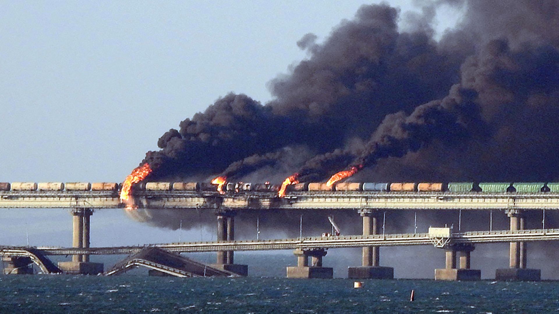 Black smoke billows from a fire on the Kerch bridge that links Crimea to Russia, after a truck exploded, near Kerch, on October 8, 2022. /AFP
