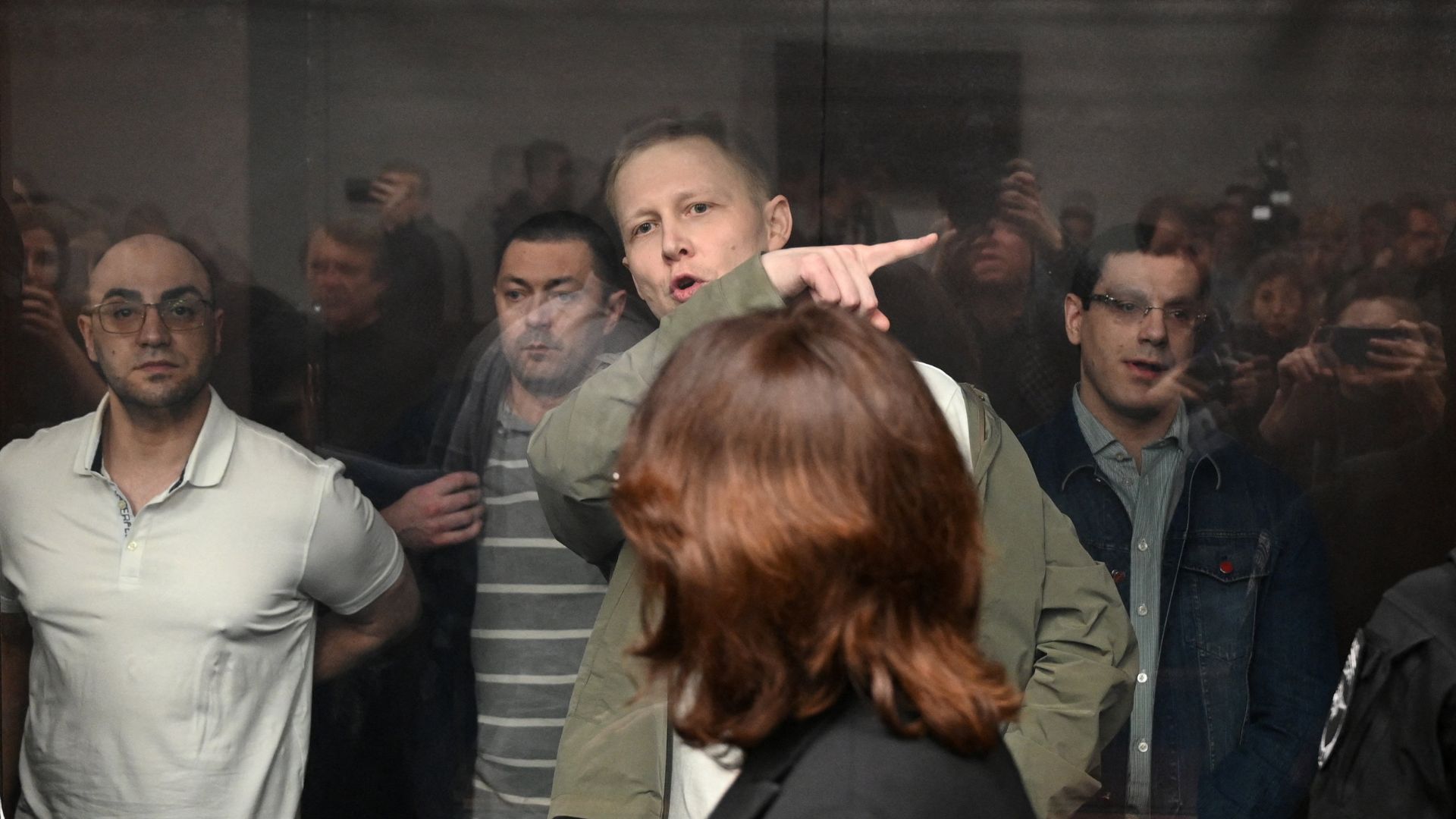 Oleg Antipov and other defendants, convicted of involvement in the bomb attack on the Crimean Bridge in October 2022, stand behind a glass enclosure during the court hearing in Rostov-on-Don, Russia. /Sergey Pivovarov/Reuters
