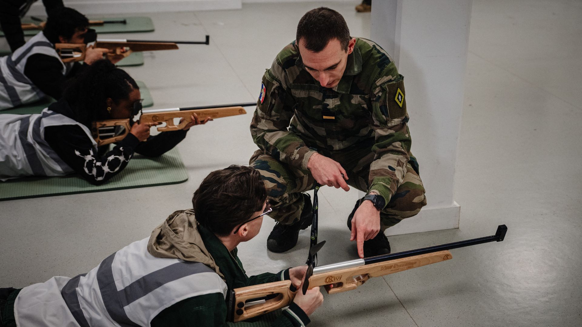 A military instructor provides guidance to participants during a laser shooting training session as part of the Defense and Citizenship Day (JDC) at Fort de Montrouge in Arcueil. /Dimitar Dilkoff/AFP
