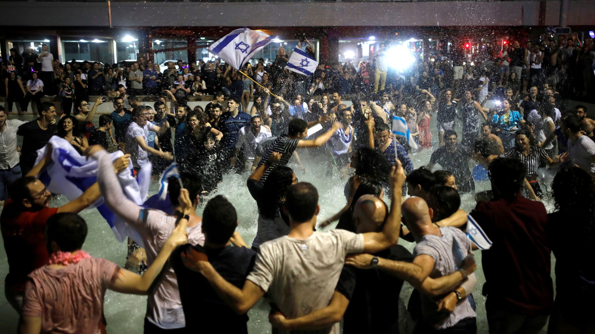 Israeli fans celebrate at Rabin Square in Tel Aviv after Israeli singer Netta Barzilai won the 2018 Eurovision Song Contest 2018. /Corinna Kern/Reuters
