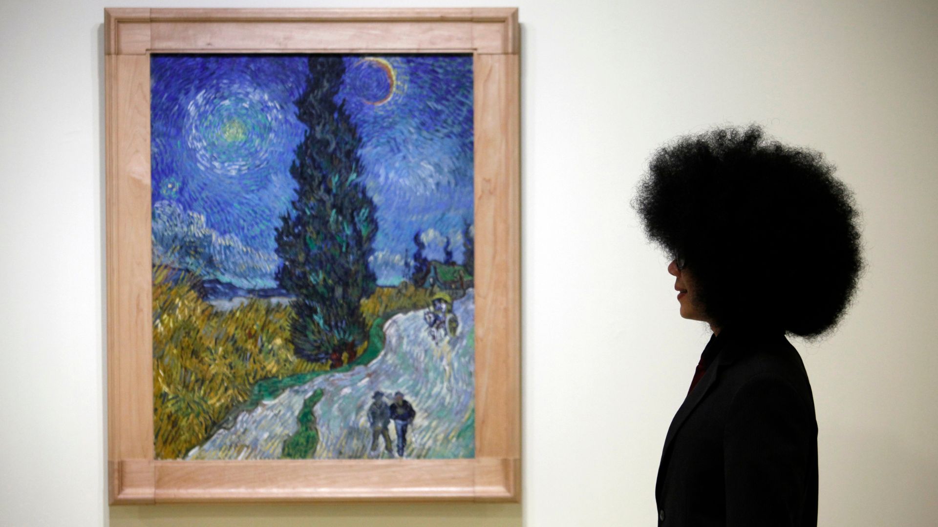 A gallery visitor beside the painting 'Country Road in Provence by Night by 19th century Dutch painter Vincent van Gogh. /Nicky Loh/Reuters
