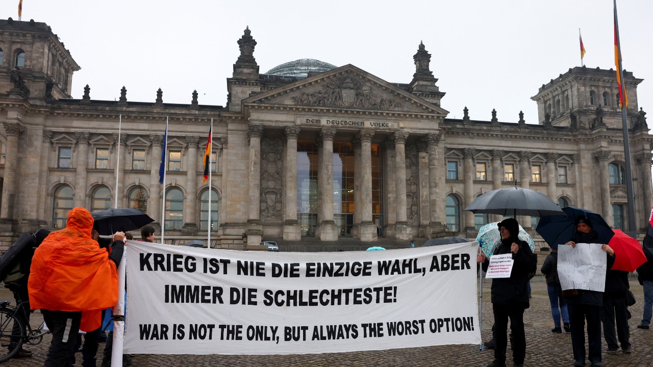 Activists hold a banner in front of the Reichstag building during a protest against compulsory military service in Berlin, Germany. /Christian Mang/Reuters