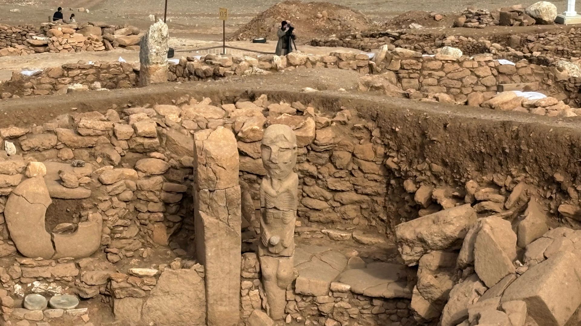 A pillar and a human statue stand at the archeological site of Karahantepe in Sanliurfa, which offers clues about Neolithic beliefs and rituals. /Fulya Ozerkan/AFP
