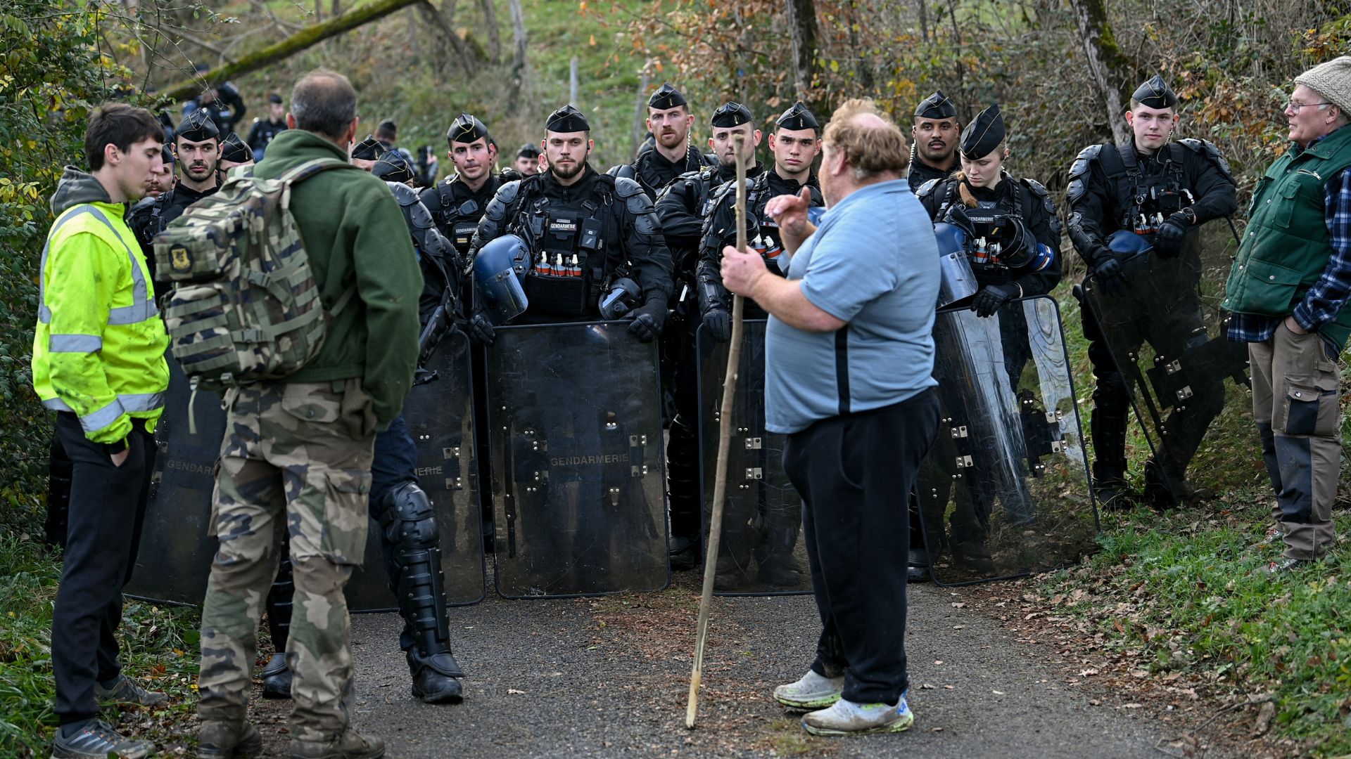 Farmers stand before French gendarmes as they try to prevent the slaughter of a 200-cow herd in Les-Bordes-sur-Arize, southwestern France on December 11. /Matthieu Rondel/AFP
