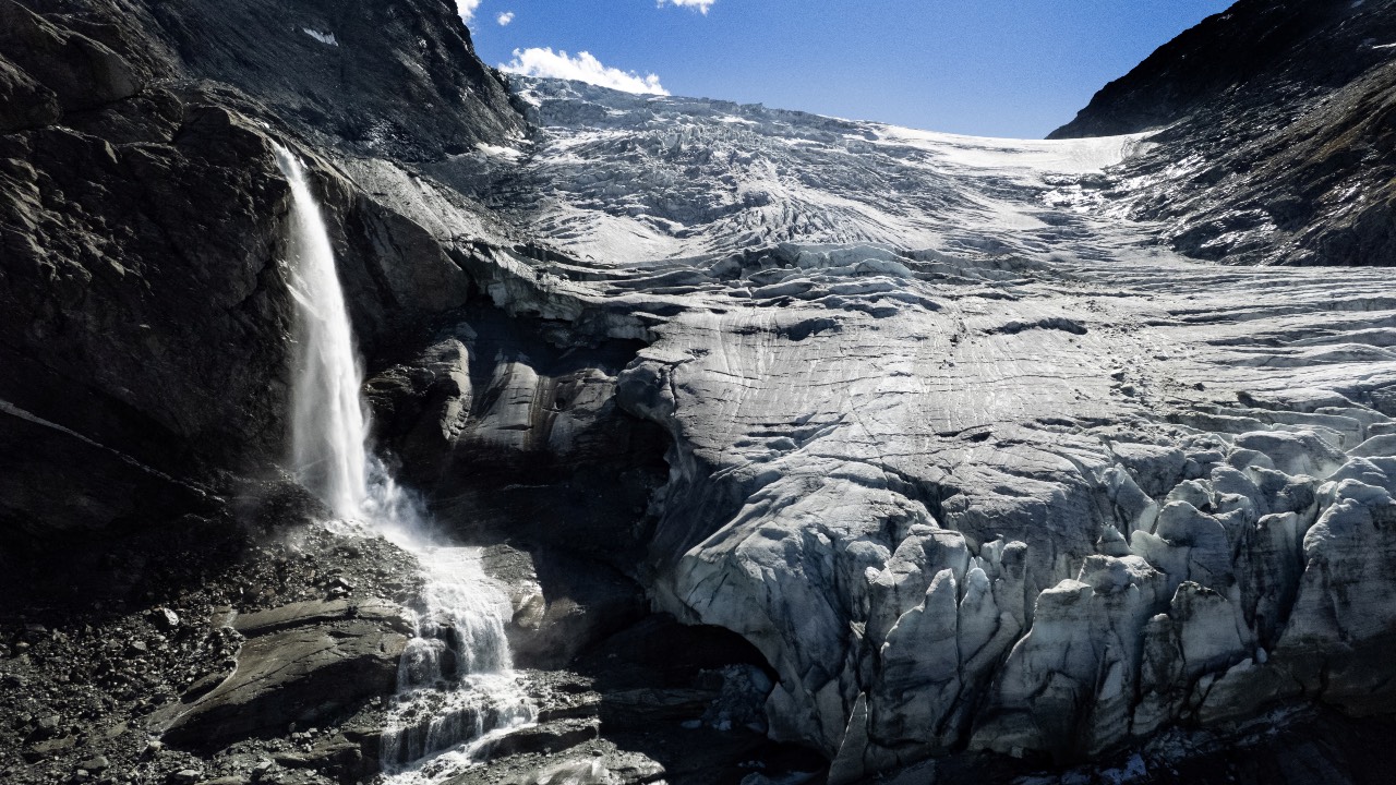 A drone view shows water from melting ice running down the side of the Turtmann glacier on a warm summer day in Turtmann, Switzerland. /Denis Balibouse/Reuters