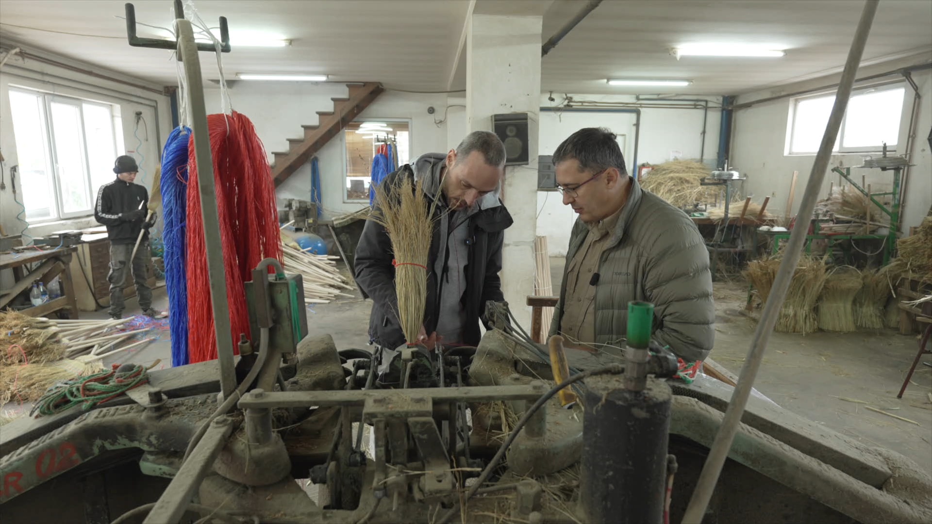 CGTN's Aljosa Milenkovic (R) takes a close look at the broom-making process. /CGTN