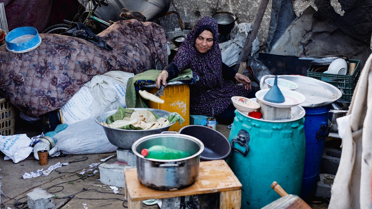 A Palestinian woman prepares food in Jabalia, northern Gaza Strip. /Mahmoud Issa/Reuters