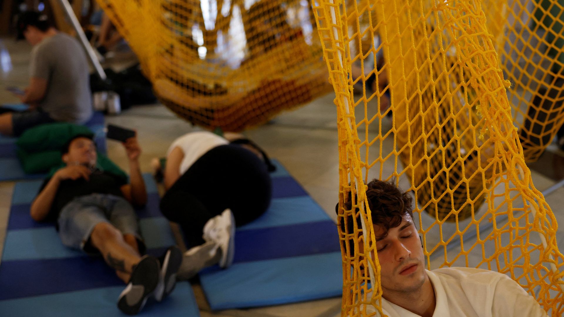 People hang out at a climate shelter at the Circulo de Bellas Artes cultural center during a heatwave in Madrid last August. /Susana Vera/Reuters

