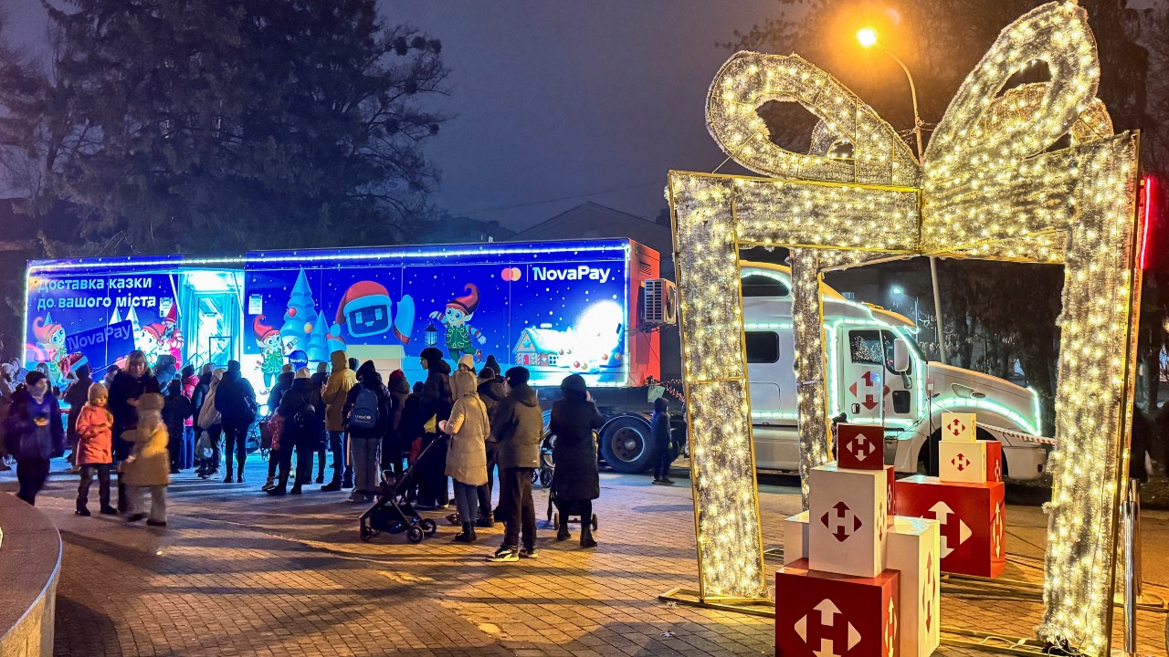 People queue for photos next to a Nova Post company truck with Christmas decorations in Poltava, Ukraine. /Vitalii Hnidyi/Reuters