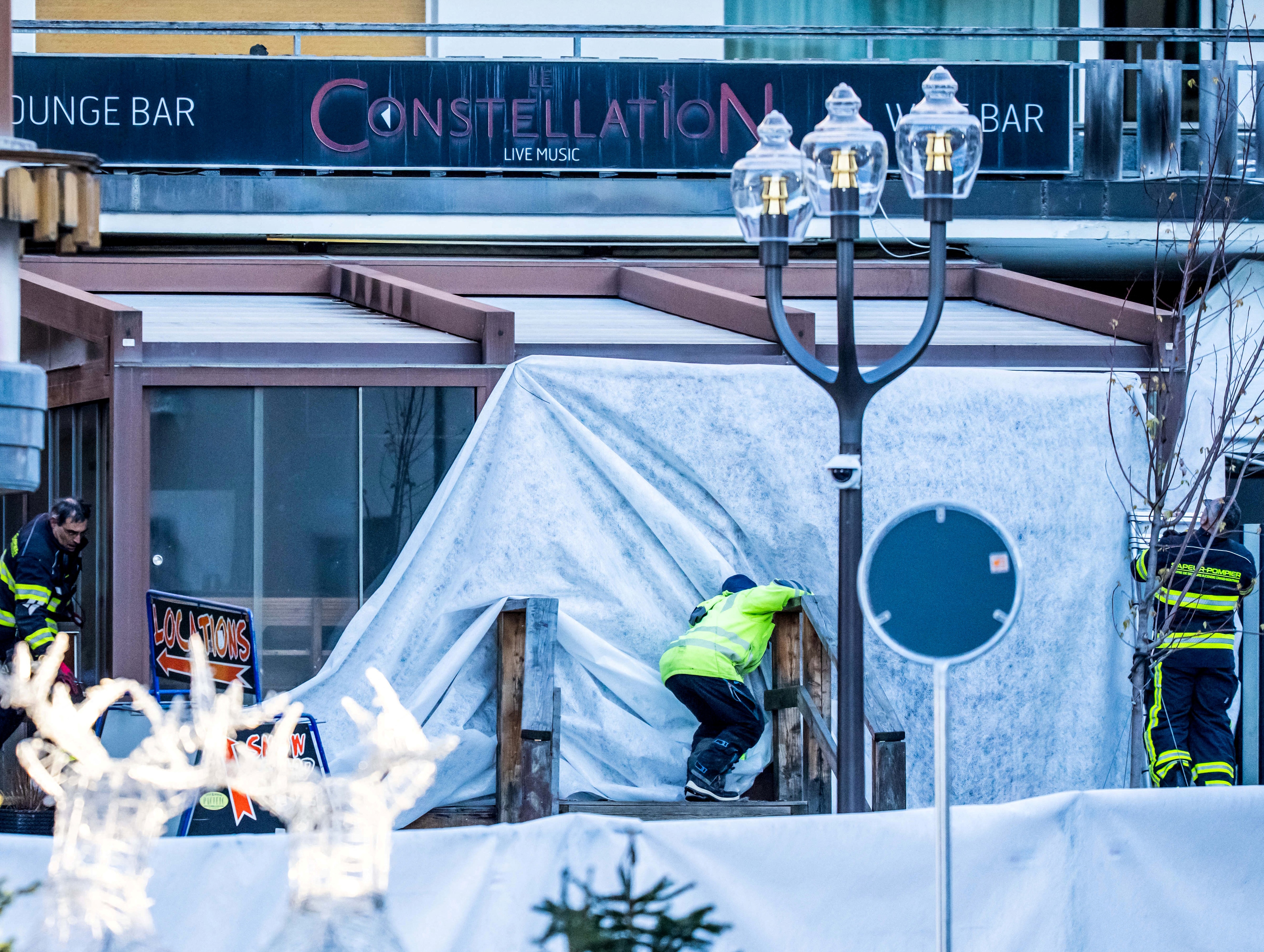 Rescuers and fire-fighters work at the site of an explosion that ripped through the bar Le Constellation in Crans-Montana. /Maxime Schmid/AFP
