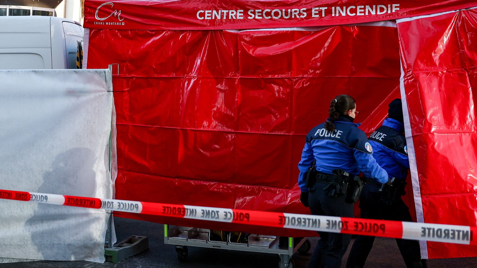 Police officers enter the sealed-off area outside the bar on Friday. /Denis Balibouse/Reuters
