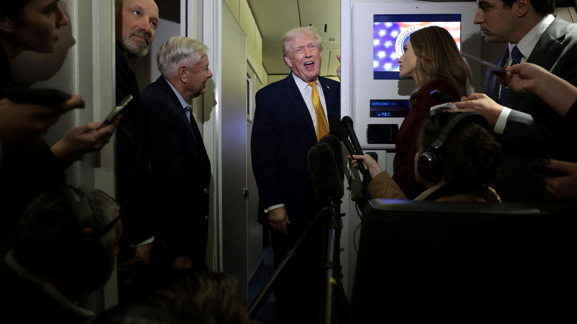 US President Donald Trump, with Secretary of Commerce Howard Lutnick and Senator Lindsey Graham, speaks to reporters aboard Air Force One. /Jonathan Ernst/Reuters
