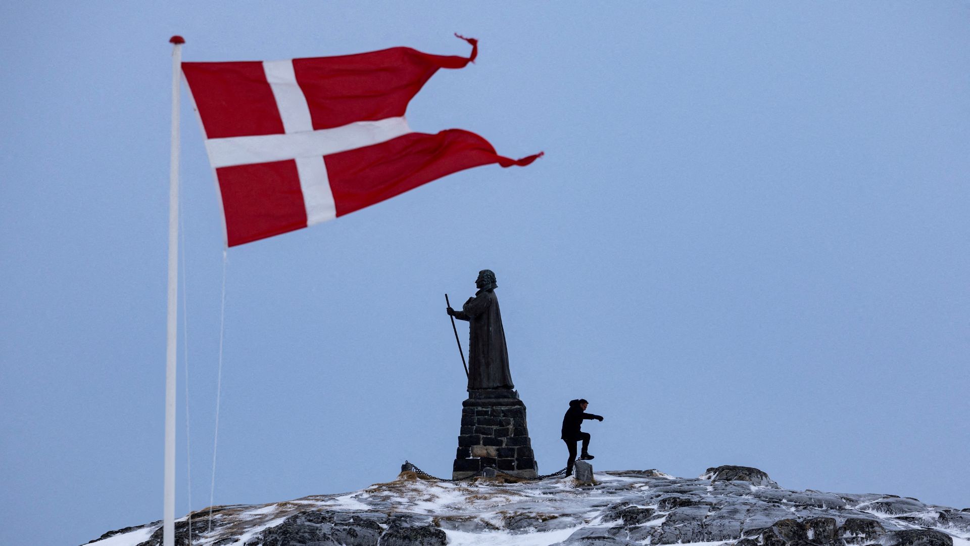 A man walks as Danish flag flutters next to Hans Egede Statue ahead of last March's general election in Nuuk, Greenland /Marko Djurica/Reuters
