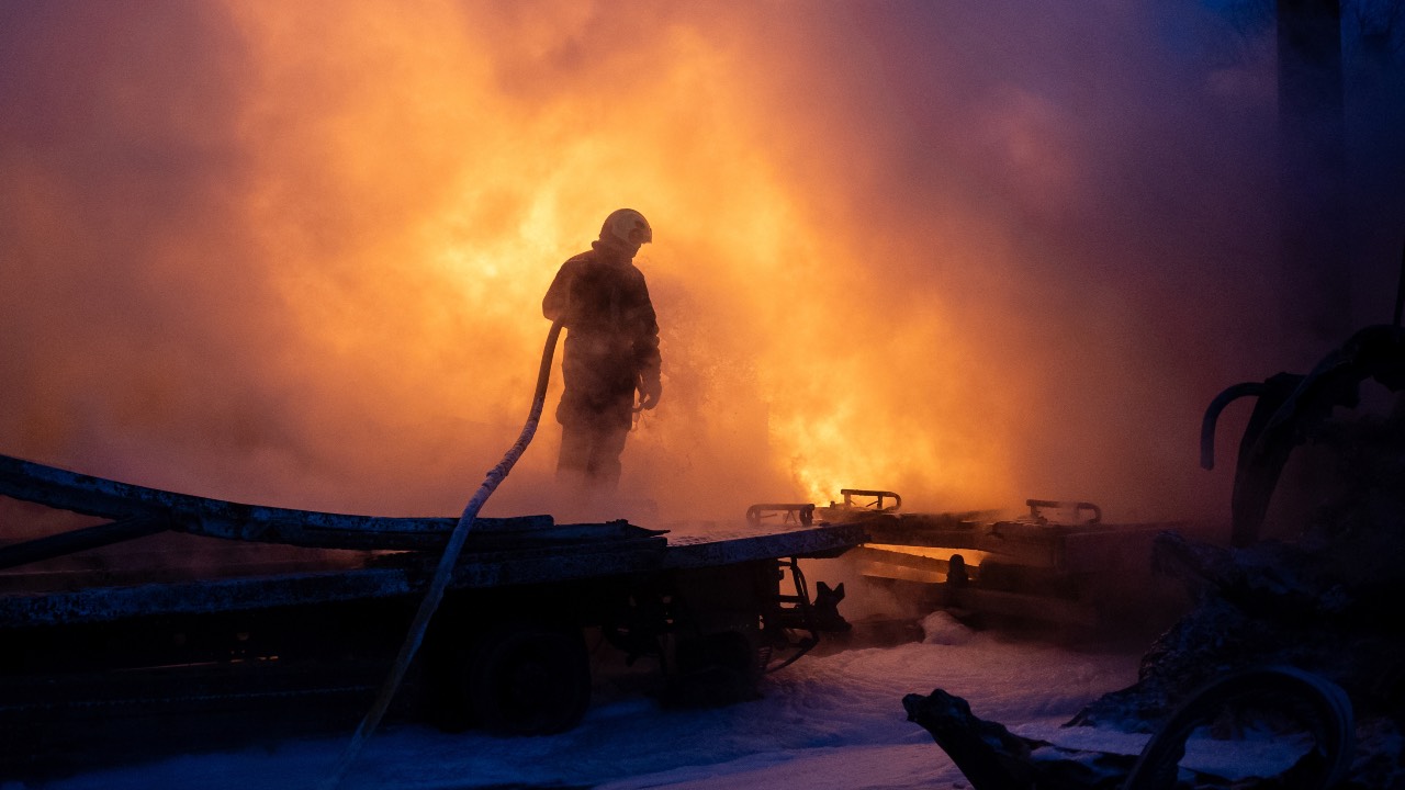 A Ukrainian emergency personnel works to extinguish a fire at the site of an air attack in Kyiv. /Oleksandr Magula/AFP