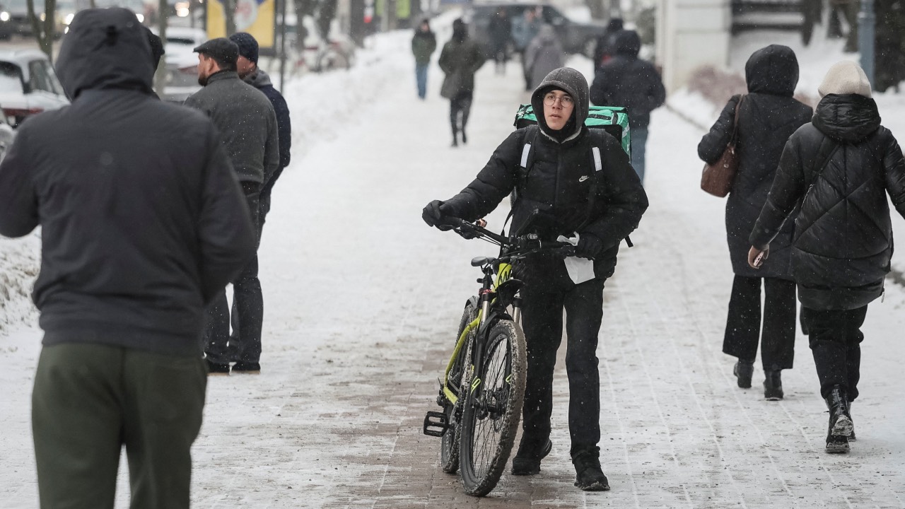 A resident with a bicycle walks on a snow-covered street on a frosty winter day in Kyiv, Ukraine. /Gleb Garanich/Reuters