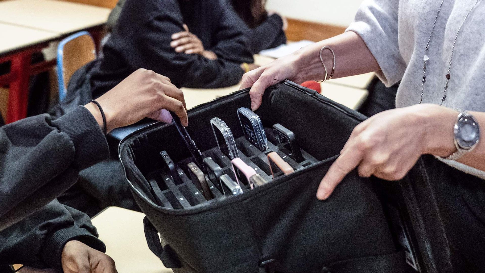 A French secondary school pupil hands in their smartphone ahead of a lesson. /Reuters