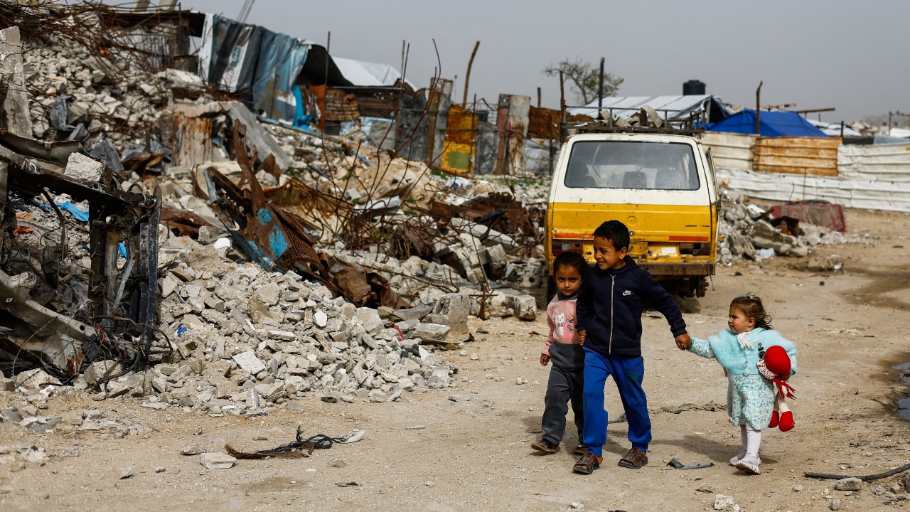 Palestinian children walk past the rubble of residential buildings destroyed during the war, in Gaza City. /Mahmoud Issa/Reuters