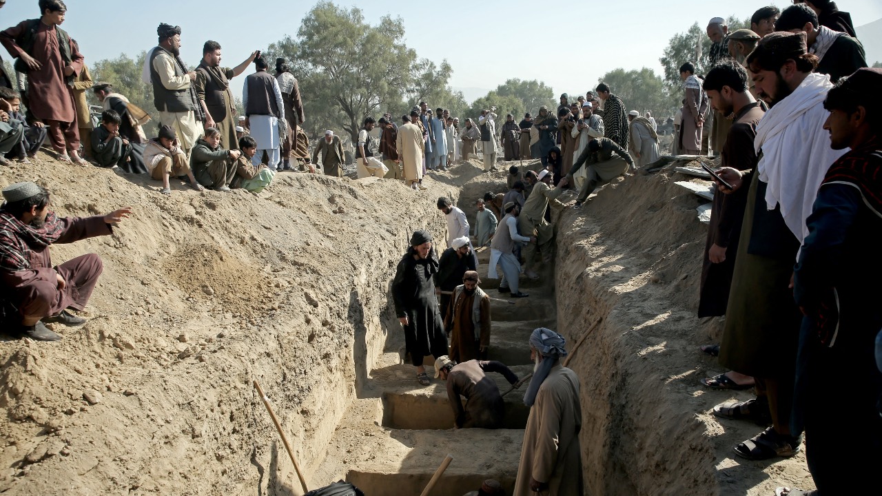 Afghan residents dig mass graves for the victims, killed in an overnight Pakistani air strike, during a funeral ceremony at the Girdi Kas village in Bihsud district, Nangarhar province. /AFP