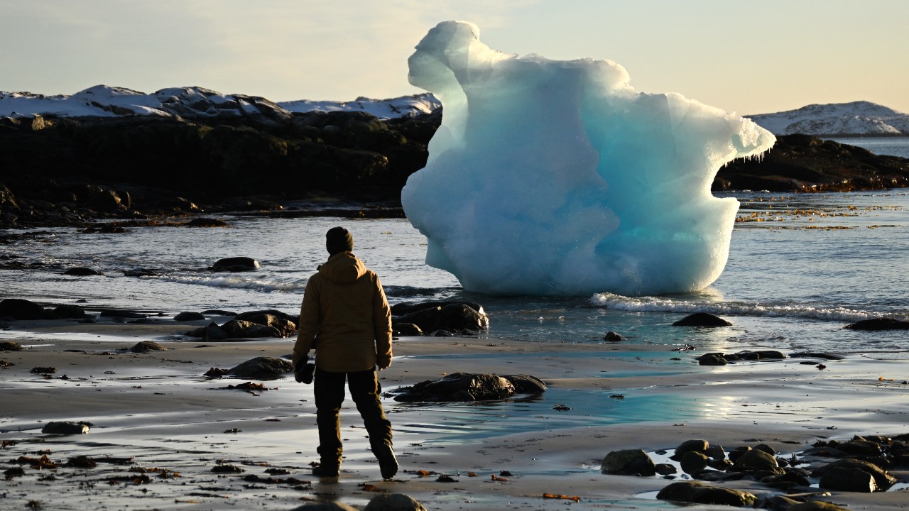 A man stands at an ice block at the coastline in the city of Nuuk, western Greenland. /Ina Fassbender/AFP