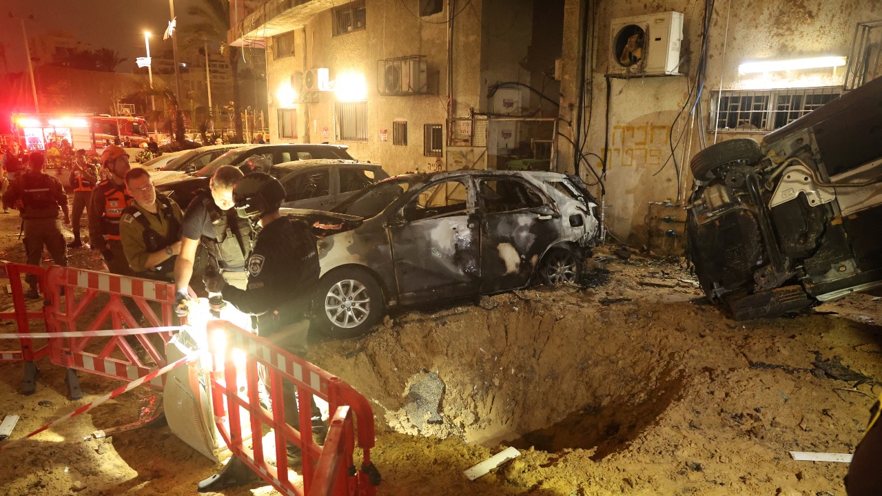 Israeli security forces check the damage to cars after a rocket strike in Holon, in the Tel Aviv District. /Jack Guez/AFP