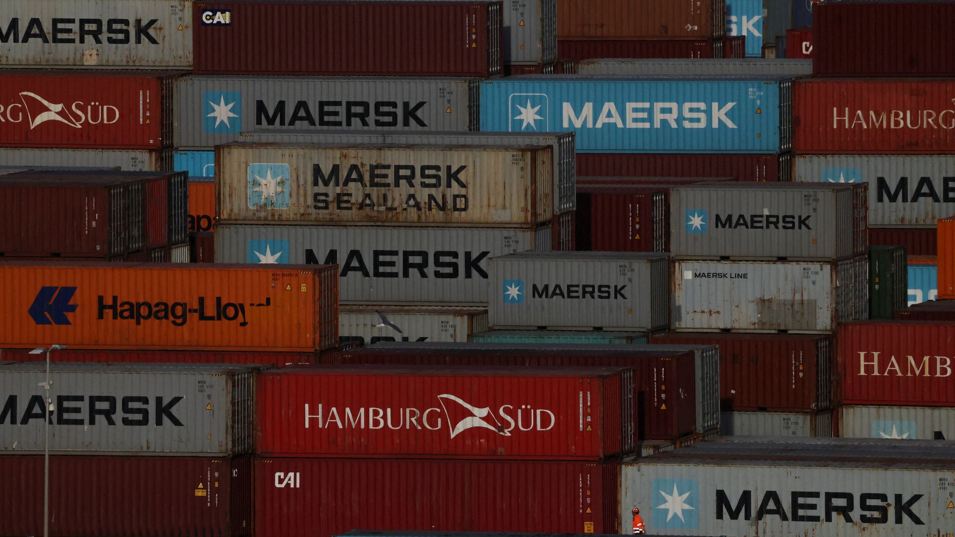 A worker walks past shipping containers at Algeciras port, in Cadiz, Spain. /Nacho Doce/Reuters

