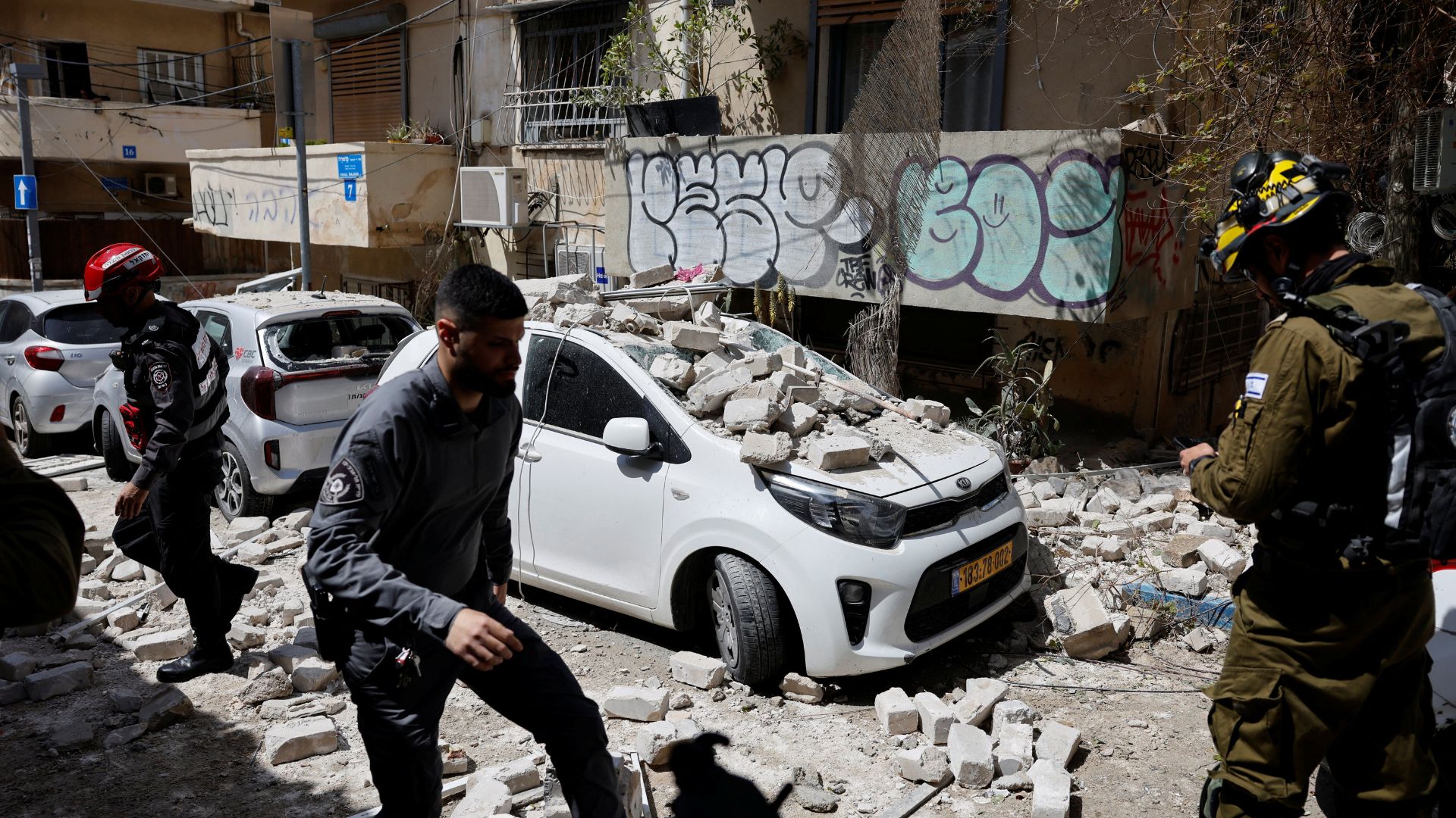 Security personnel work at the site of a damaged building following barrages of Iranian missiles in Tel Aviv./ Amir Cohen/Reuters
