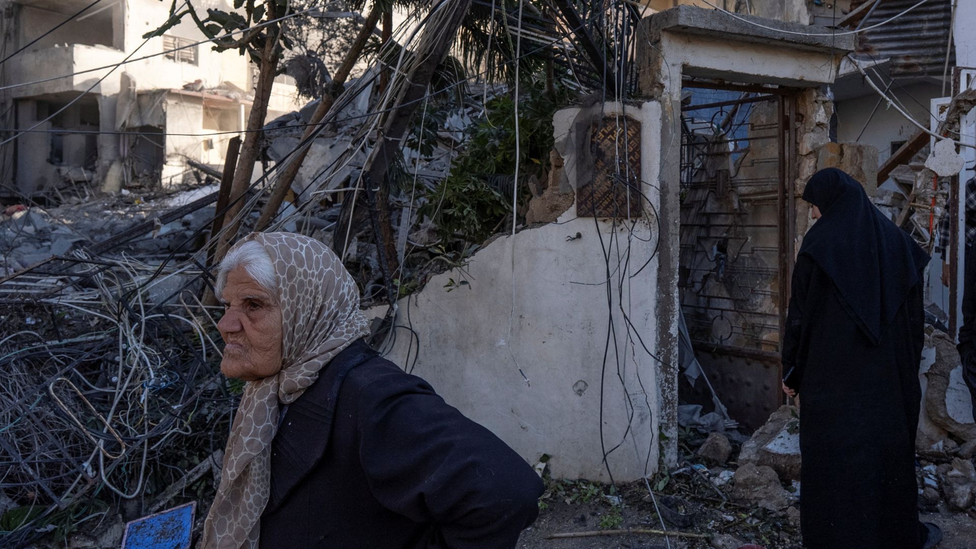 Women stand next to a building destroyed by an Israeli strike, amid escalating hostilities between Israel and Hezbollah, in Tyre, Lebanon, March 24, 2026. /Reuters/Manu Brabo