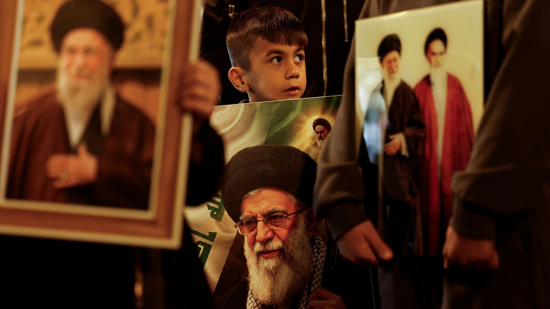 A boy carries a portrait of Iranian Supreme Leader Ayatollah Ali Khamenei during a symbolic funeral procession, in Najaf, Iraq. /Alaa Al-Marjani/Reuters