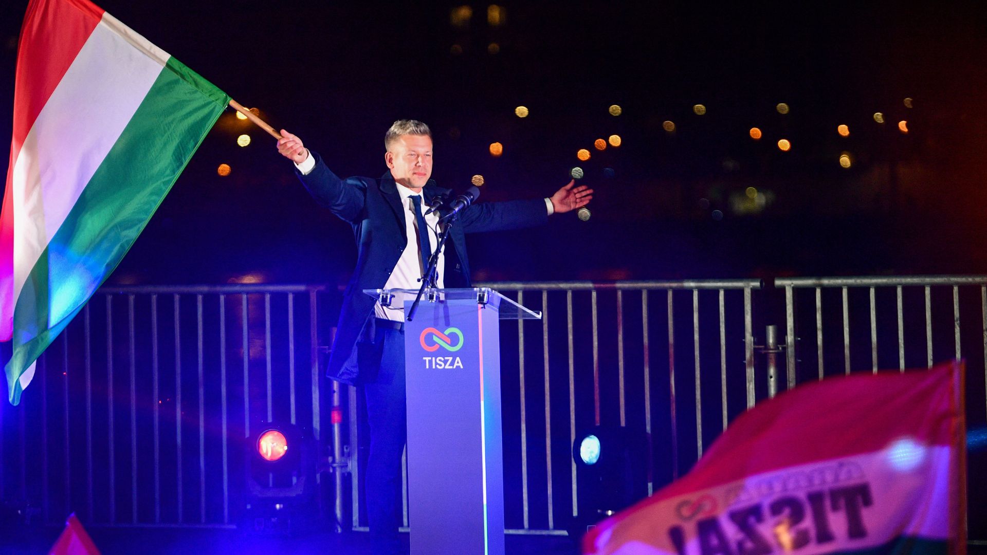 Peter Magyar, leader of the pro-European conservative TISZA party, waves the national flag during celebrations at the election night party in Budapest. /Ferenc Isza/AFP