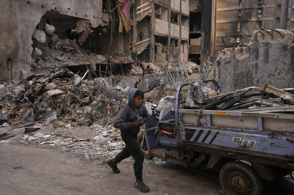 A boy collects scrap metal amid debris at the site of a building destroyed in an Israeli airstrike last Wednesday, in central Beirut, Lebanon, Tuesday, April 14, 2026. /Hassan Ammar/AP Photo