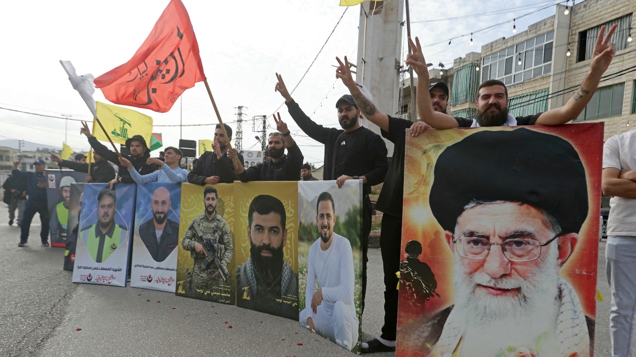 A Hezbollah supporter holds a portrait of slain Iranian supreme leader Ayatollah Ali Khamenei while celebrating a ceasefire with Israel, in the southern Lebanese town of Marwanieh. /Mahmoud Zayyat/AFP