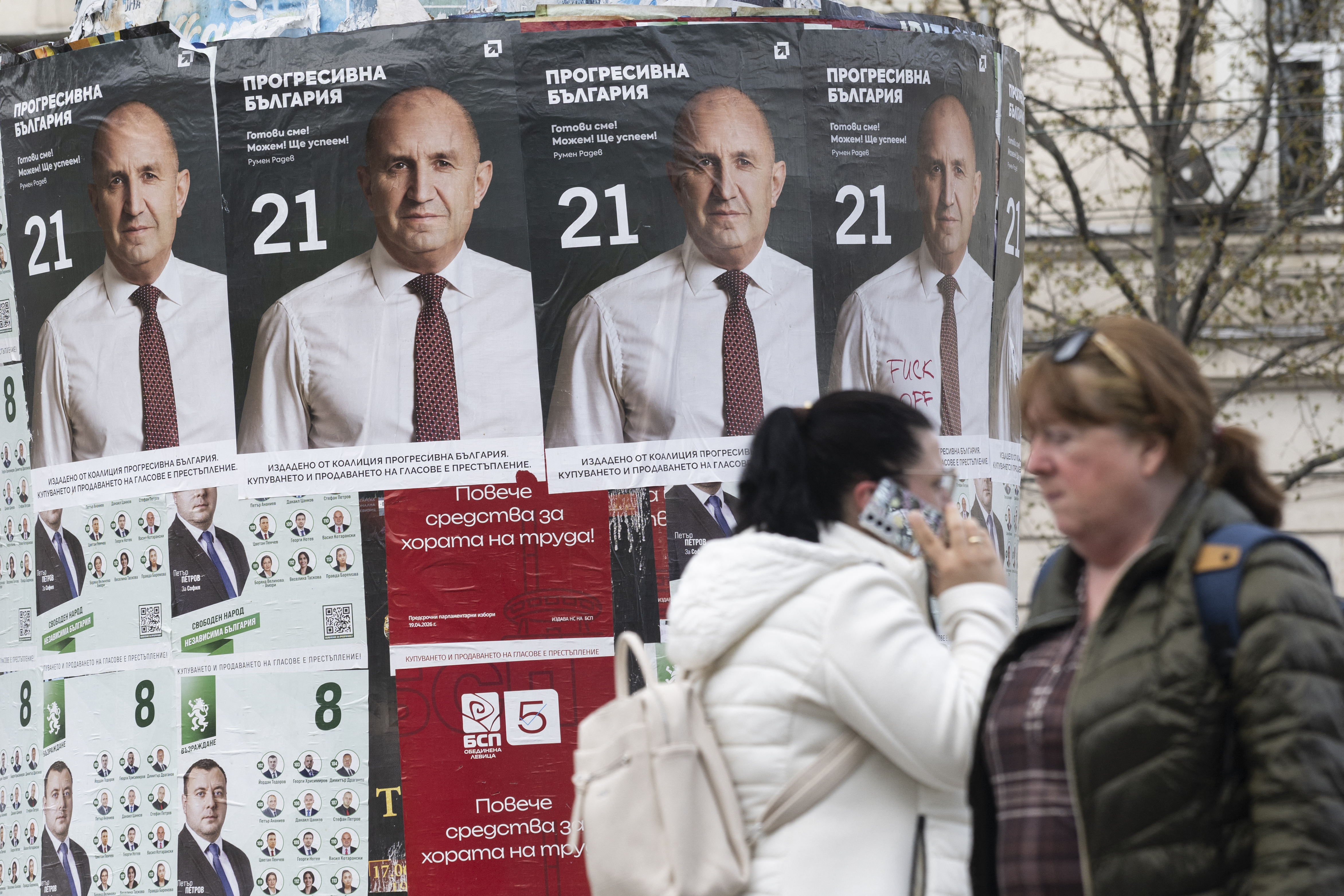 Pedestrians walk past election posters of the Progressive Bulgaria coalition's leader and former President Rumen Radev in Sofia on April 20. /Nikolay Doychinov/AFP
