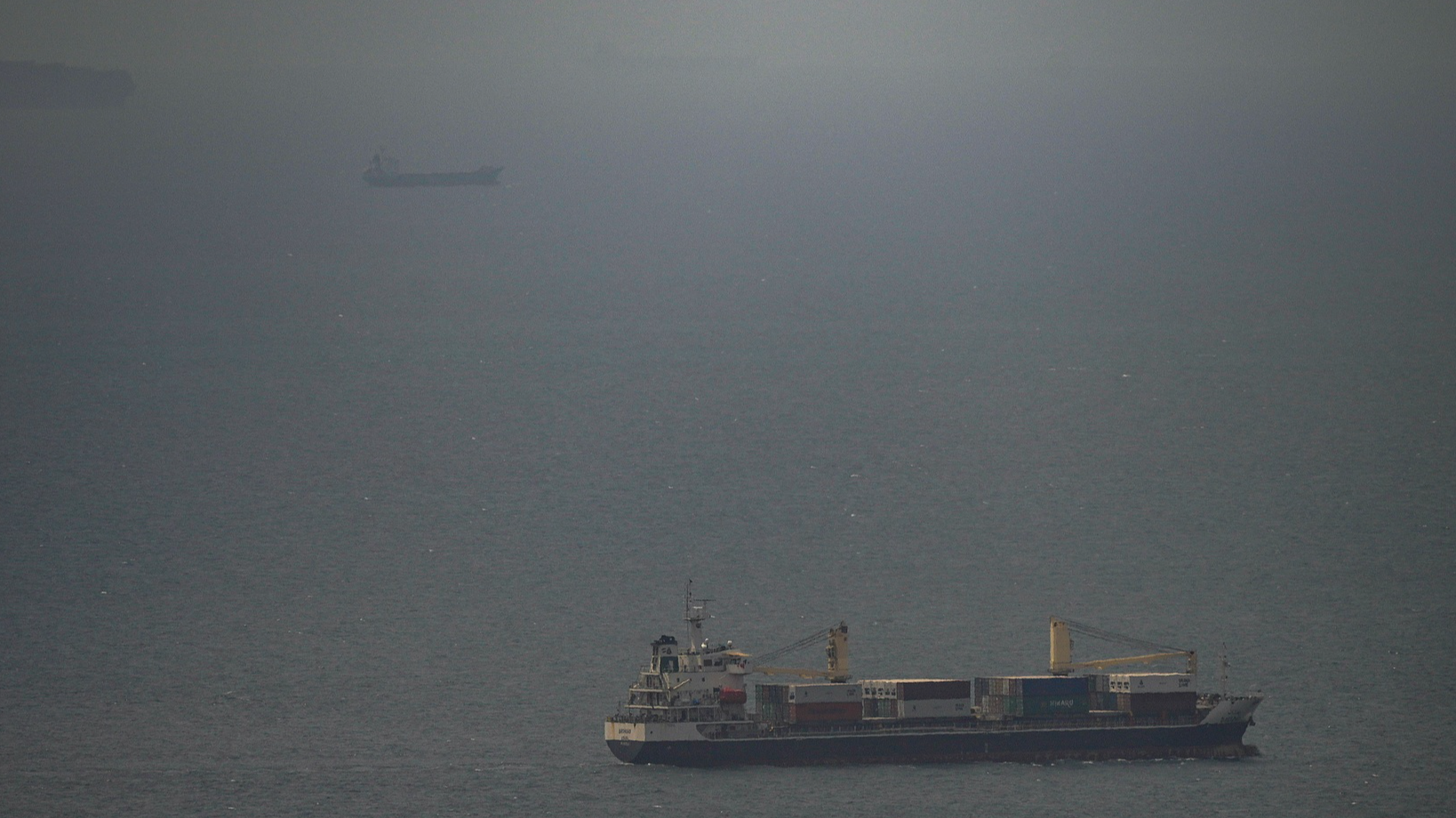 A cargo ship sails in the Persian Gulf toward the Strait of Hormuz. /AP Photo