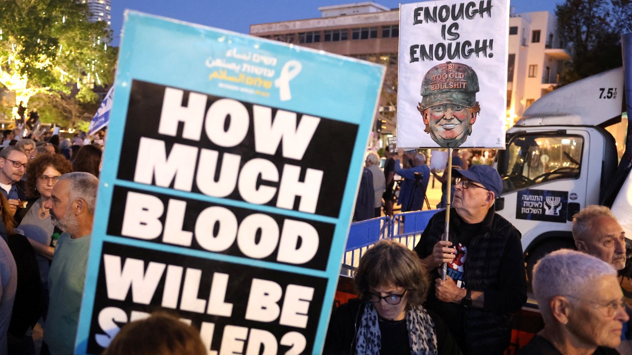 Israeli activists holding up placards demonstrate in HaBima Square against the ongoing war with Iran and against the Israeli government, in Tel Aviv. /Jack Guez/AFP