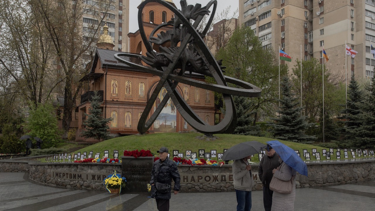 Visitors stand at a memorial for the victims of Chornobyl, on the 40th anniversary of the explosion at the nuclear power plant, in Kyiv on April 26, 2026. /Roman Pilipey/AFP