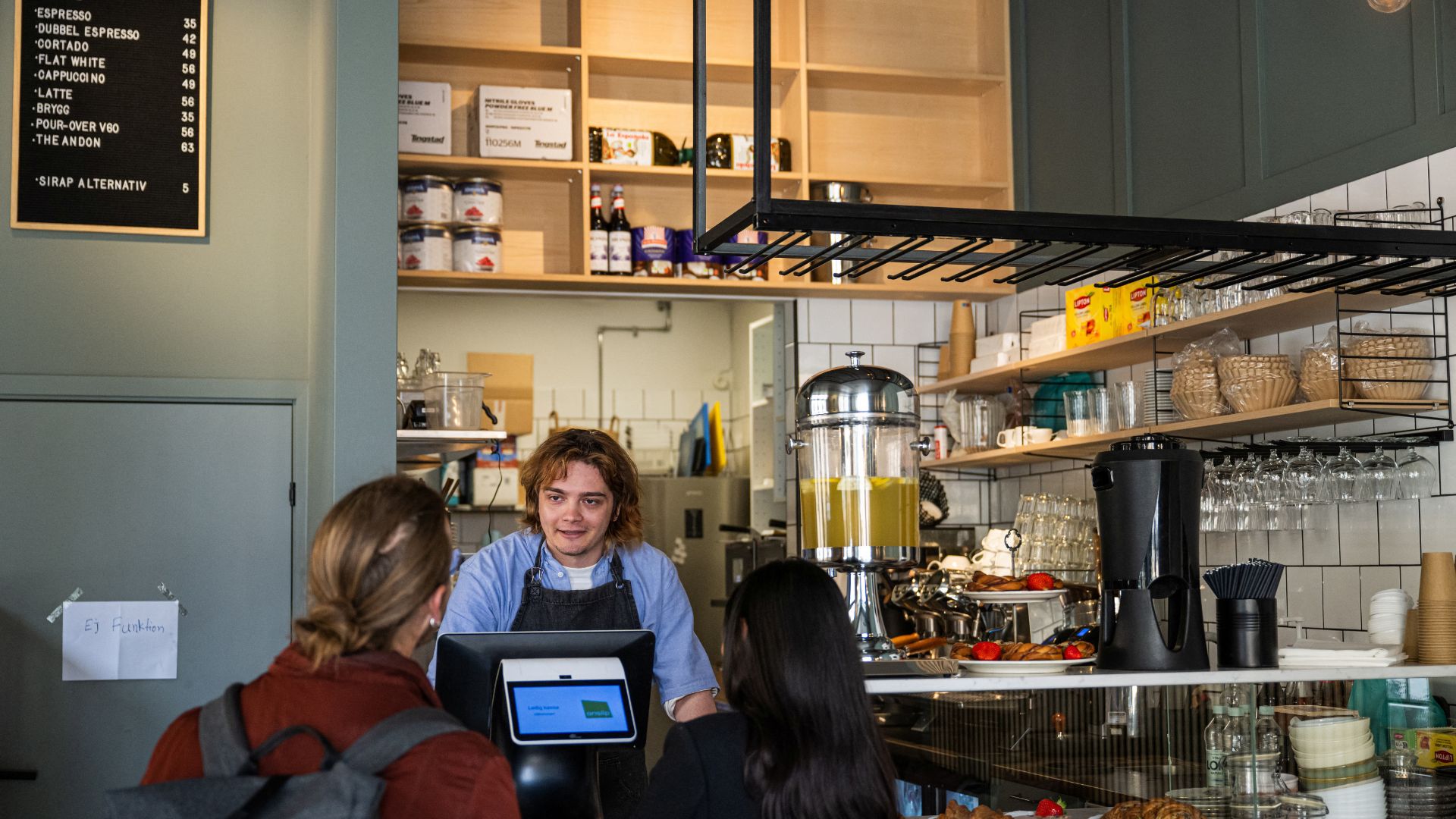 Kajetan Grzelczak, a barista, welcomes clients at the Andon Café. /Jonathan Nackstrand/AFP
