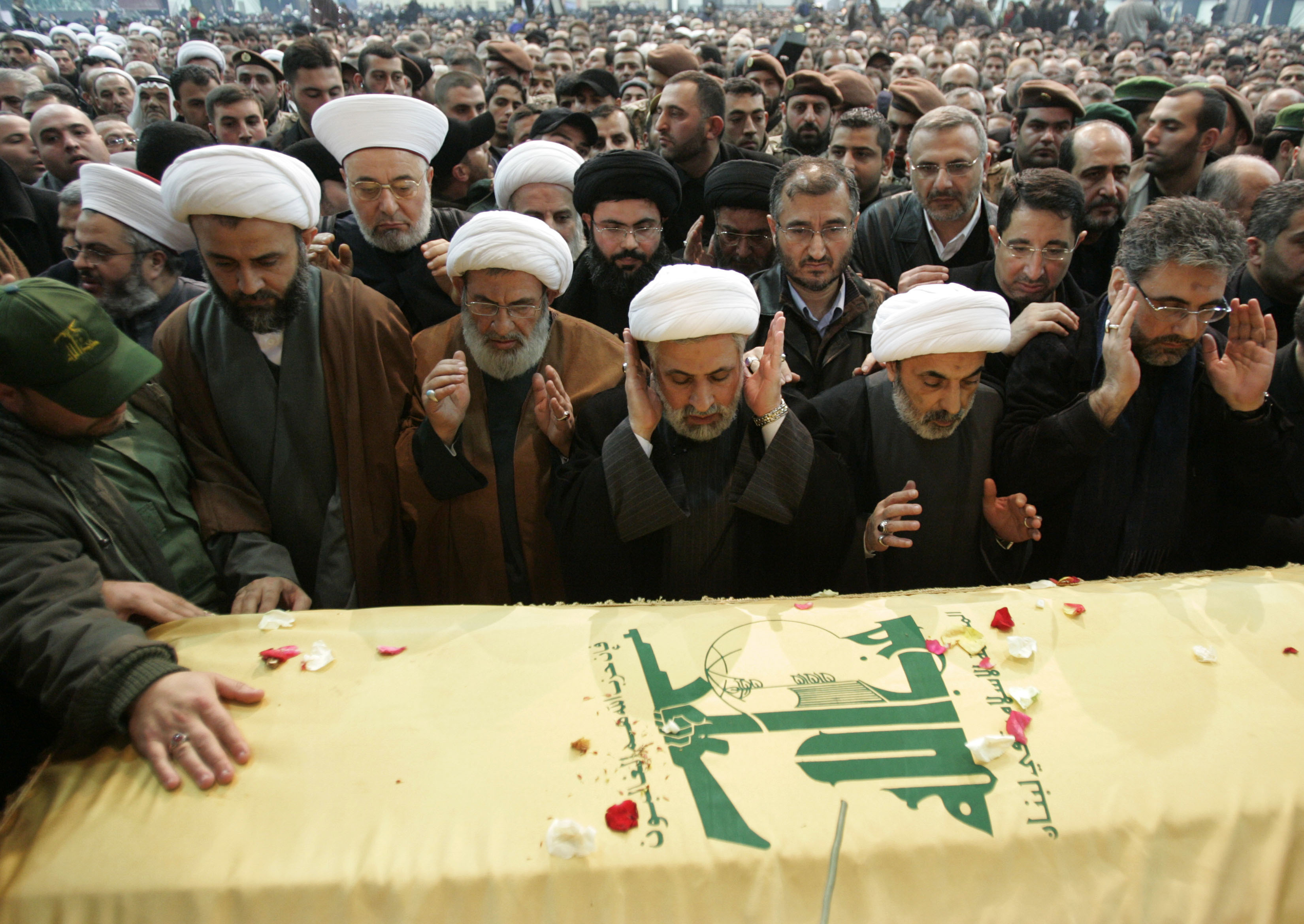 Hezbollah members pray over the coffin of their slain top commander Imad Mughniyeh, who was killed in a car bombing in Damascus, Syria, in Beirut southern suburbs, on 14 February, 2008. /Hussein Malla/AP