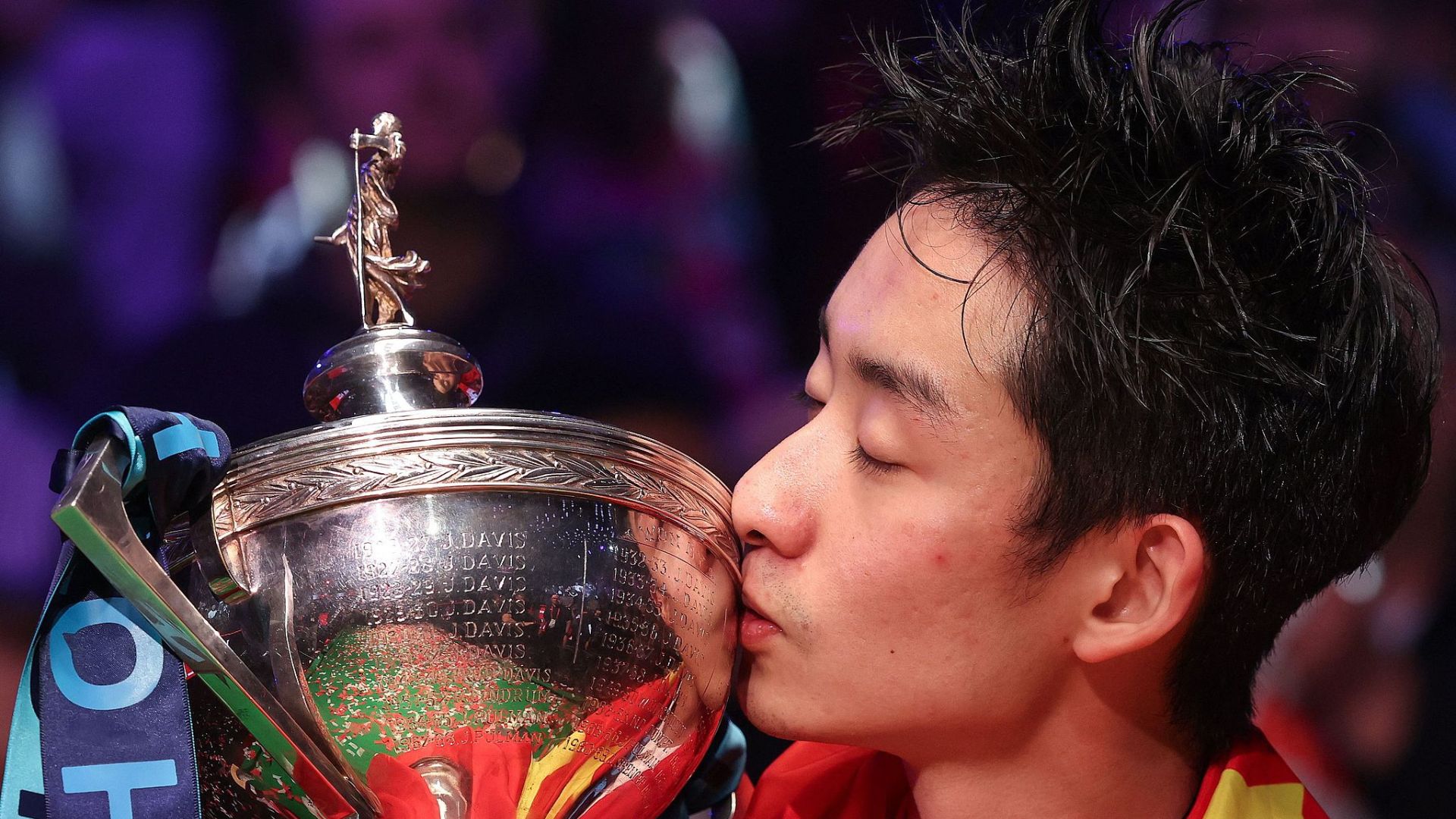 Wu Yize kisses the championship trophy during the awards ceremony. /CFP