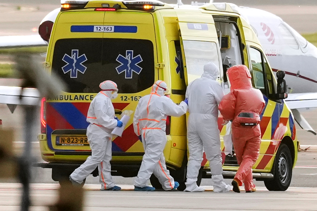 Medics escort a patient, second right, evacuated from the MV Hondius cruise ship with suspected hantavirus infection, to an ambulance after being flown to Schiphol airport, Amsterdam, Netherlands, Wednesday, May 6, 2026. /Peter Dejong/AP