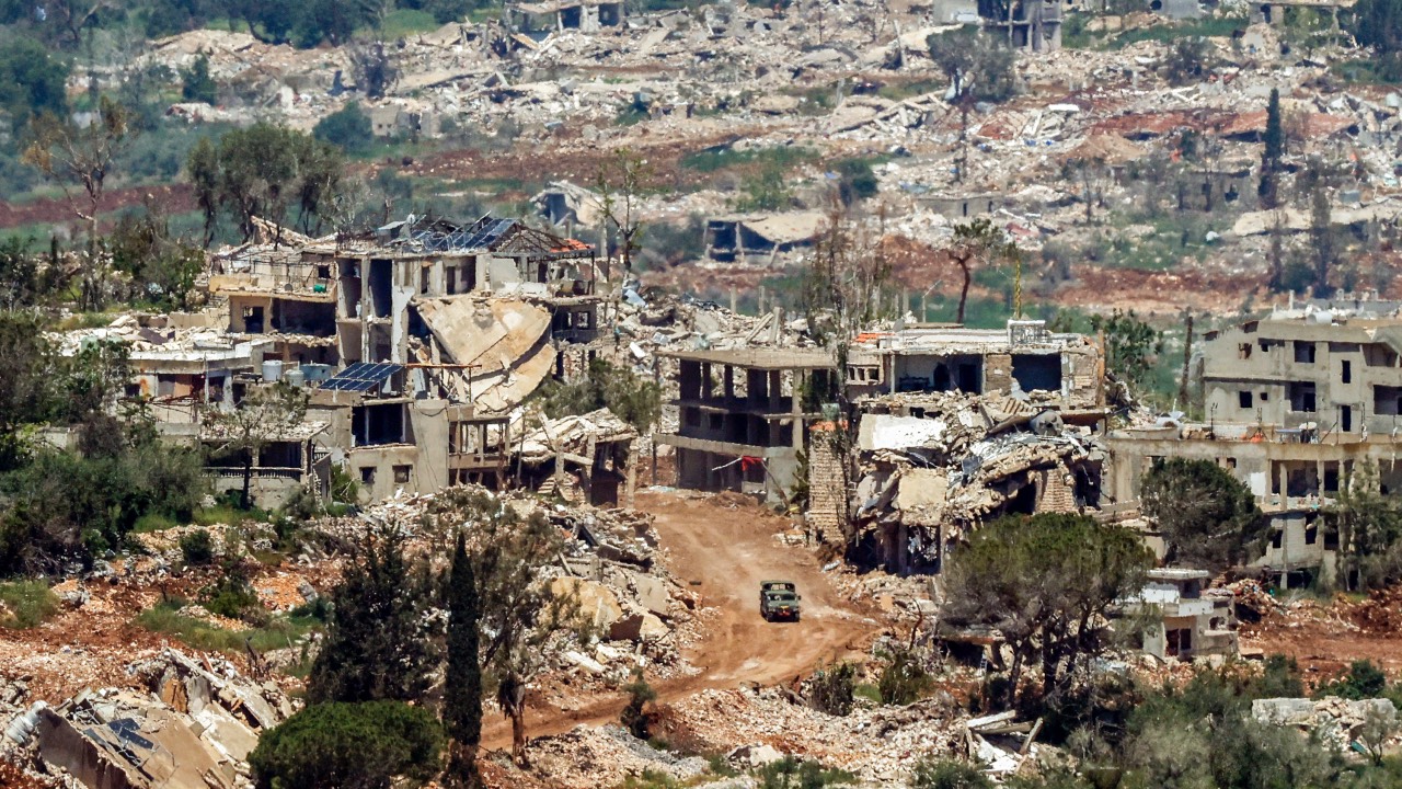 An Israeli military vehicle drives past houses destroyed in Israeli strikes in southern Lebanon as seen from a position across the border in the Upper Galilee in northern Israel. /Jalaa Marey/AFP