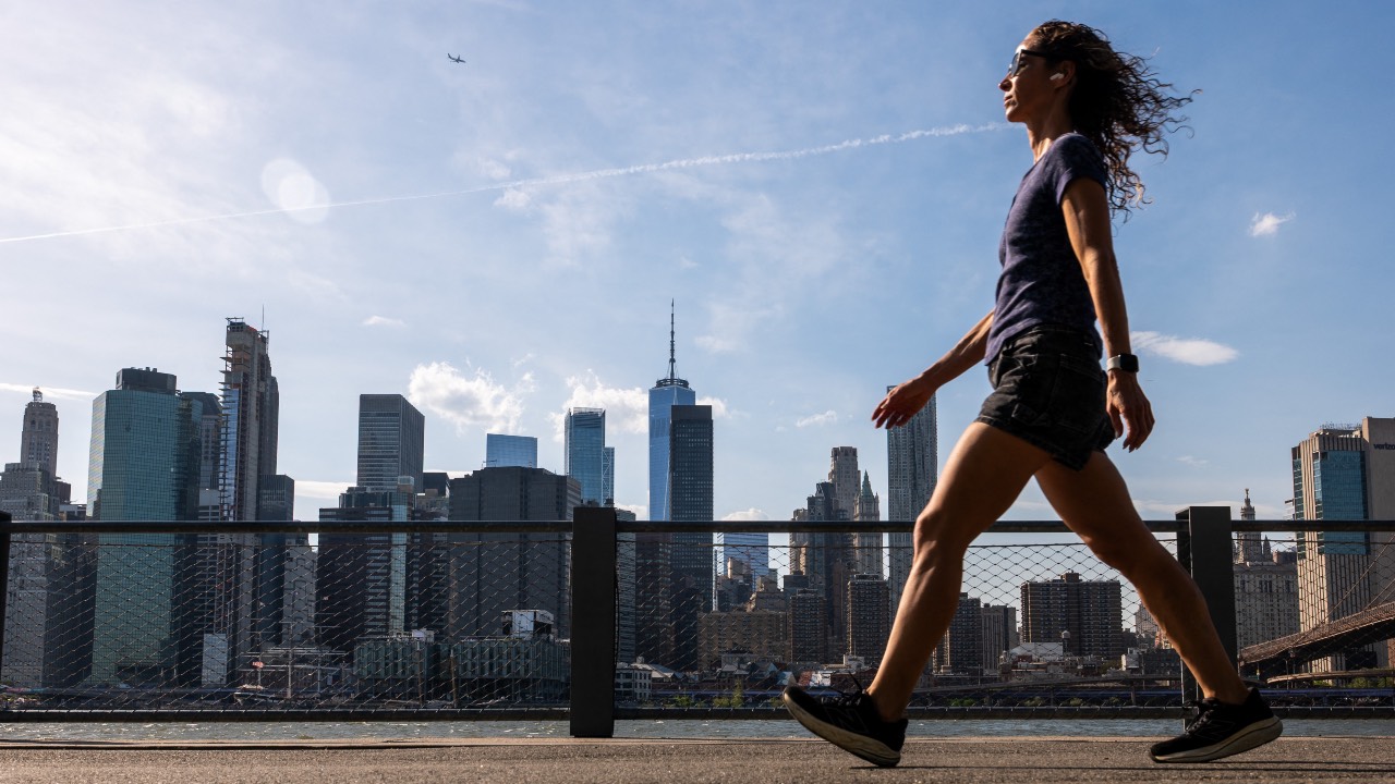 A woman walks through Brooklyn Bridge Park on an unseasonably warm spring day in New York City. /Spencer Platt/Getty Images/AFP