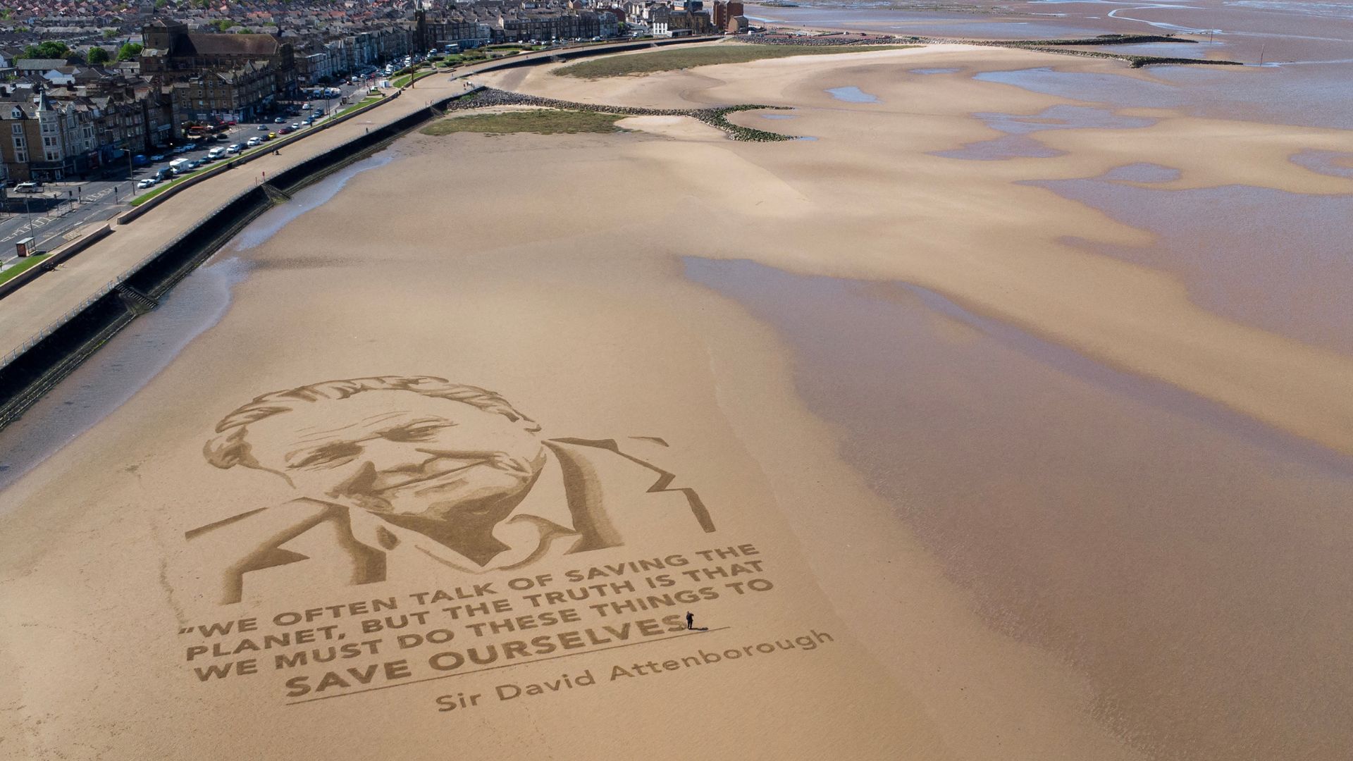 A sand drawing of David Attenborough by the arts organization Sand In Your Eye, on Morecambe beach, northern England, in celebration of his 100th birthday. /Annabel Lee-Ellis/AFP
