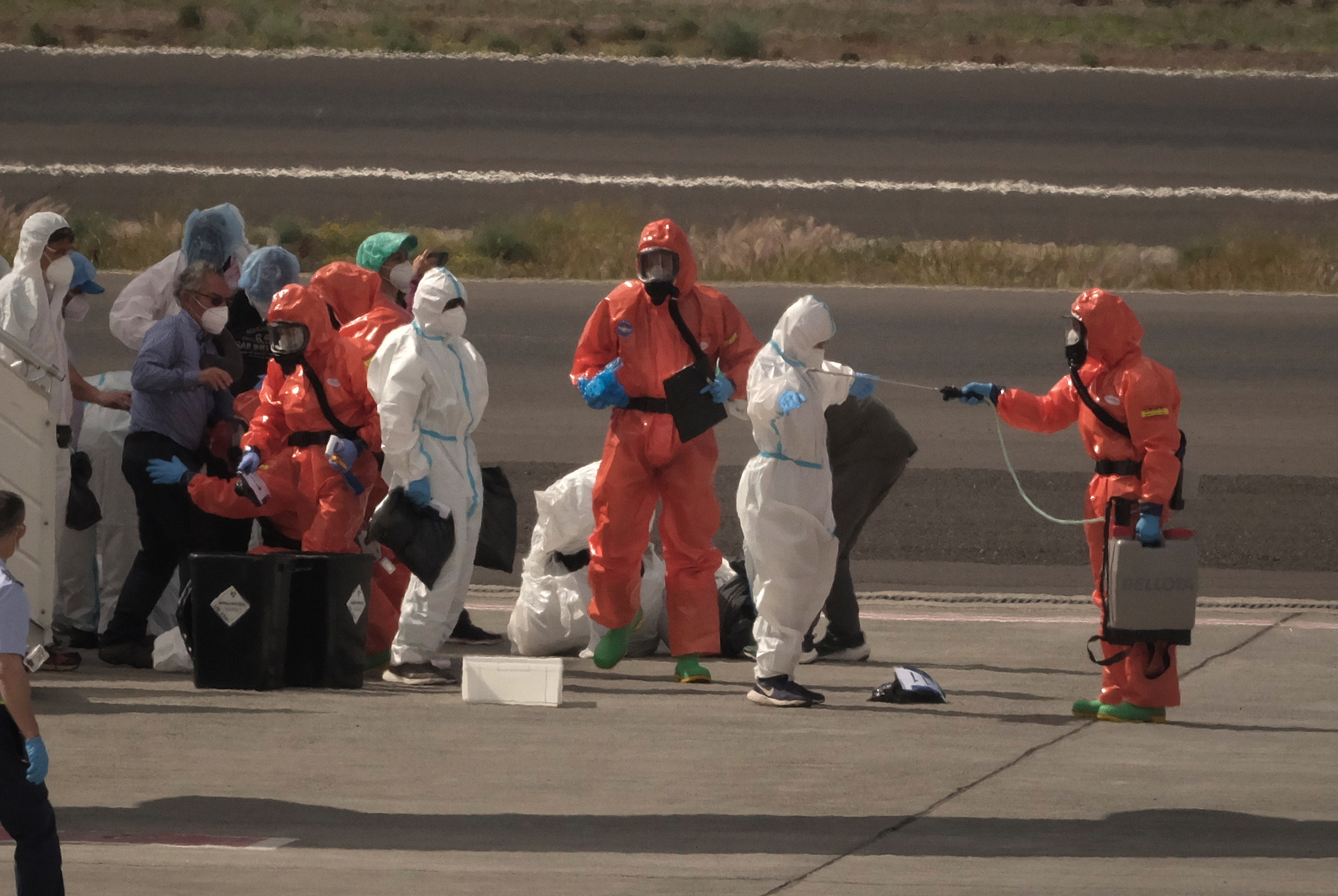 Passengers are sprayed with disinfectant by Spanish government officials before boarding a plane after disembarking from the hantavirus-stricken cruise ship MV Hondius at Tenerife airport in the Canary Islands, Spain, Sunday, May 10, 2026. /Arturo Rodriguez)