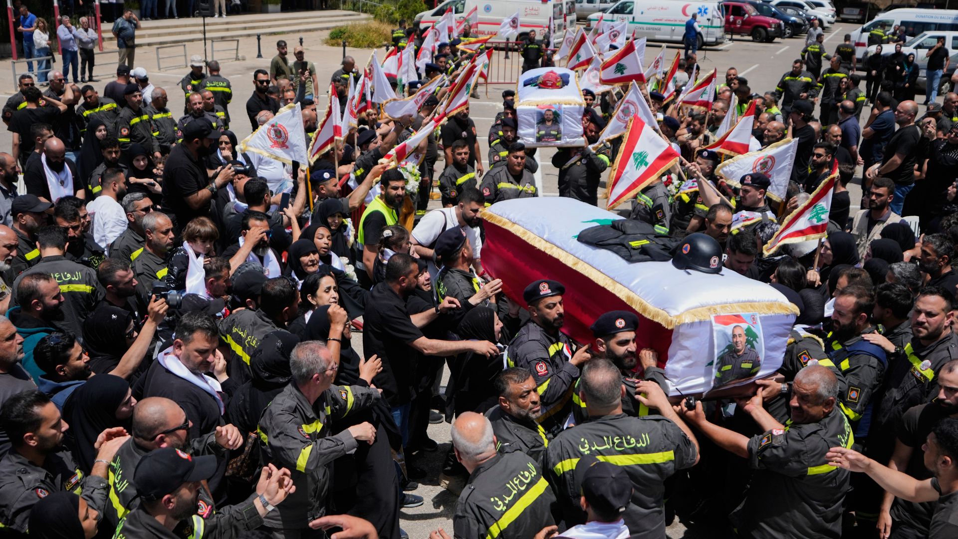 Lebanese Civil Defense members carry the coffins of two of their colleagues who were killed on Tuesday in an Israeli airstrike during a funeral procession in the coastal city of Sidon. /Mohammed Zaatari/AP